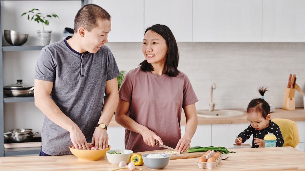 Asian family enjoying cooking together in a modern kitchen, fostering togetherness and love.
